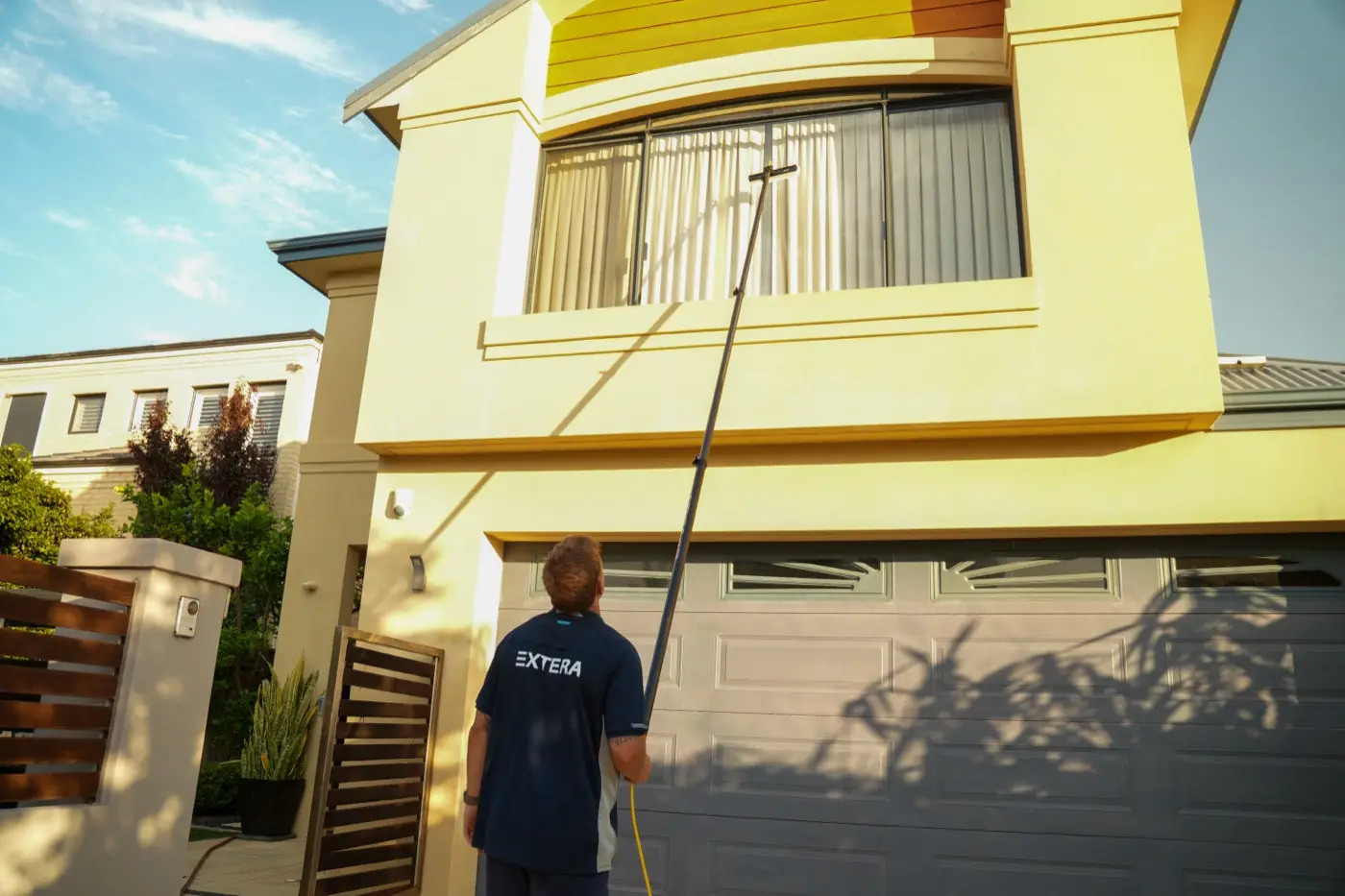 Extera cleaning an upper window with a water-fed pole in Perth